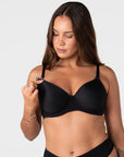 Model unclipping the traditional nursing clip on the Forever New black breastfeeding bra with drop-down cup for easy feeding access