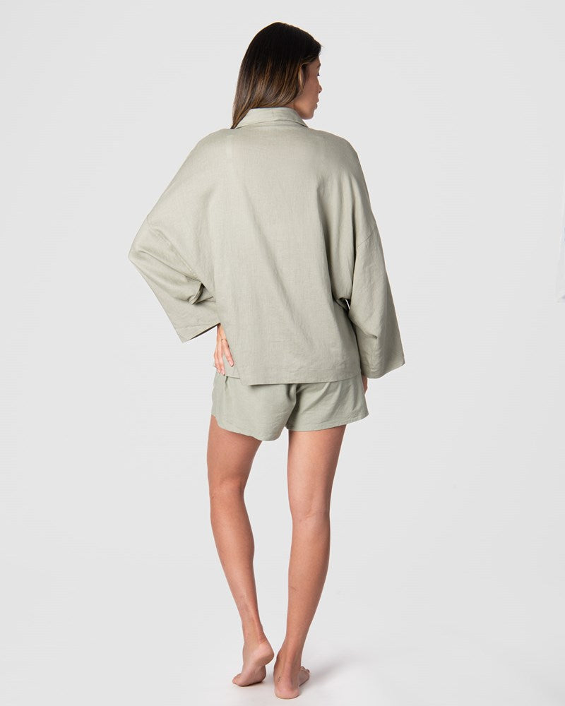 Get a glimpse of the back view of Hotmilk's versatile mix-and-match collection as it flawlessly combines the Lounge Top with the Lounge Short, creating the ultimate ensemble for warm days and evenings. These garments are impeccably crafted from a soft linen blend in a serene Sage color, promising a comfortable fit with elegant 3/4 length kimono-style sleeves. This set epitomizes the seamless blend of luxury and comfort, perfectly addressing the requirements of pregnancy, breastfeeding, and postpartum care